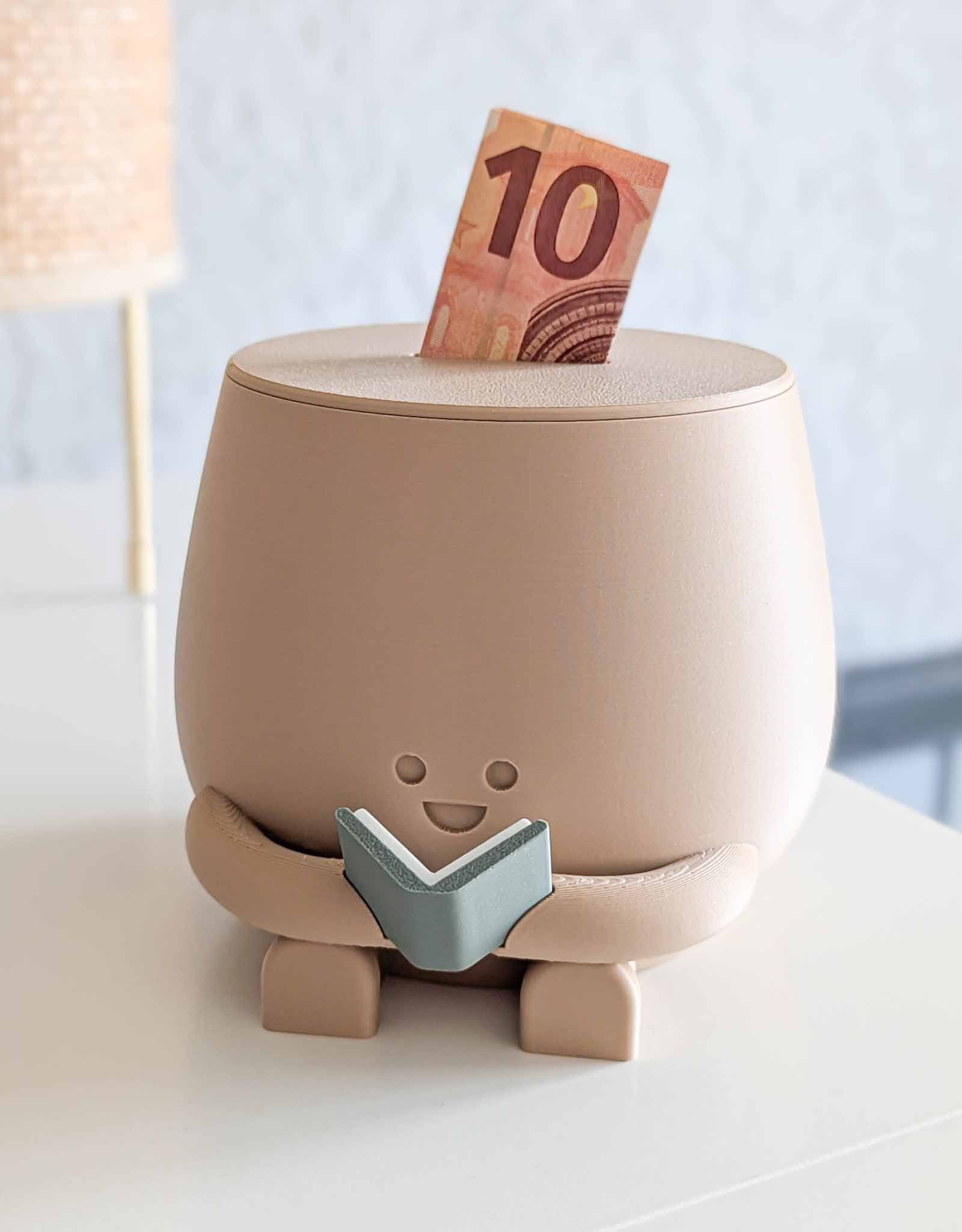 Beige piggybank with happy face reading a book