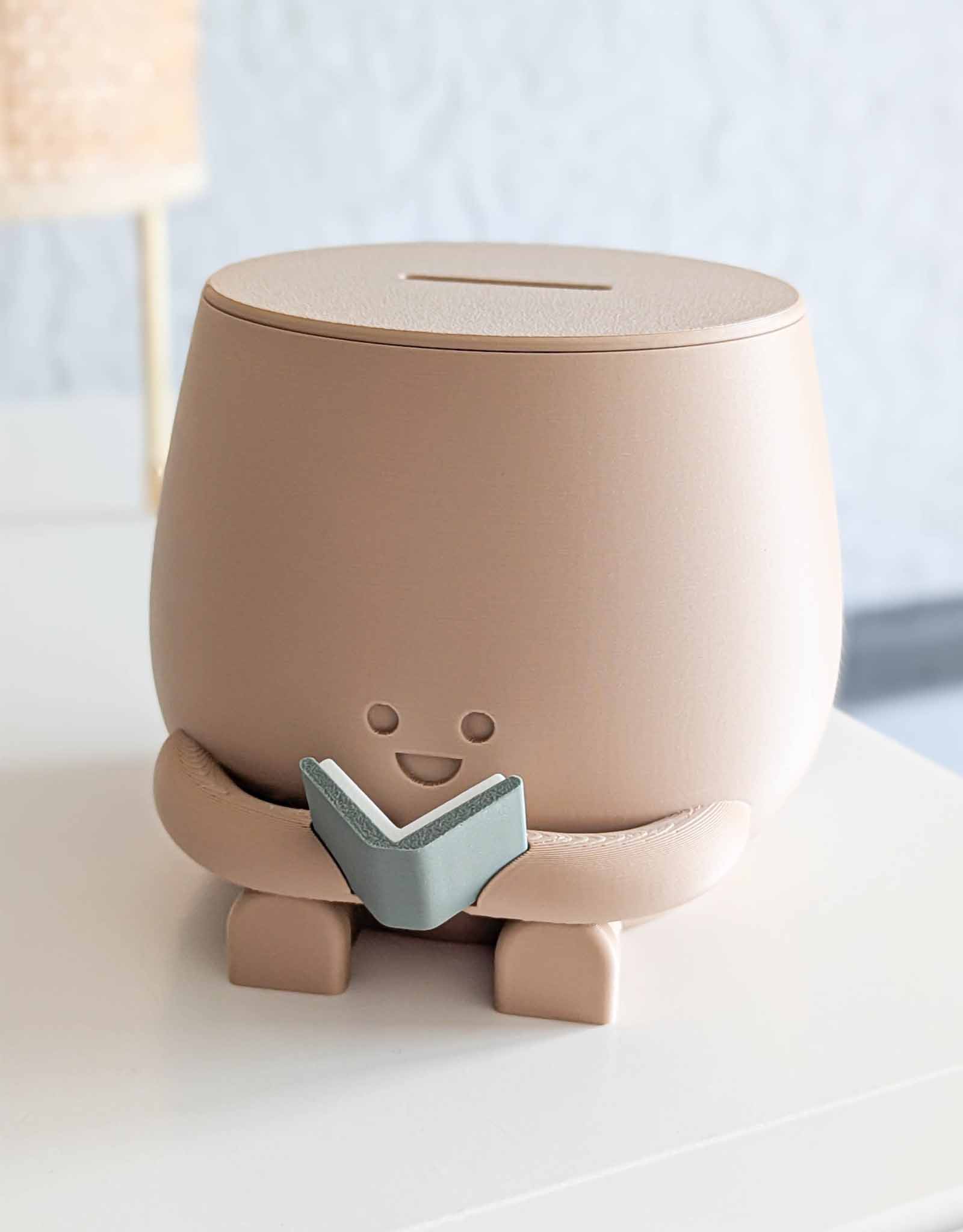 Beige piggybank with happy face reading a book