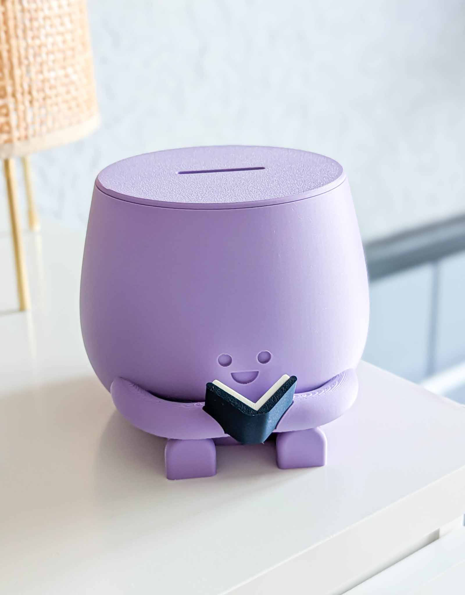 Purple piggybank with happy face reading a book