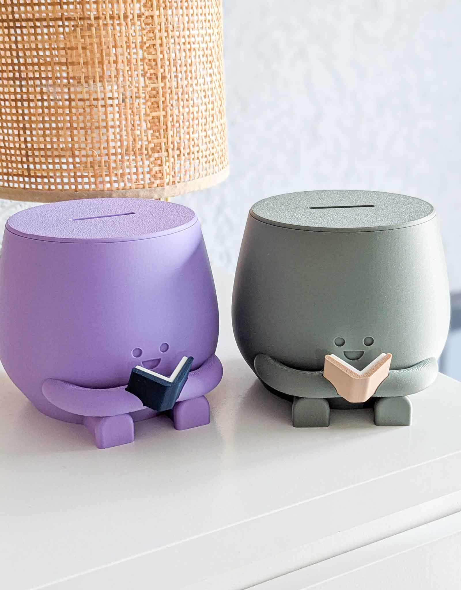Purple and dark green piggybank with happy face reading a book