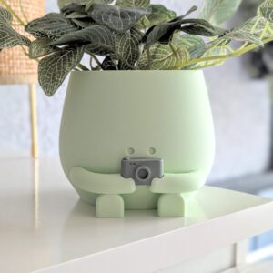 camera plant pot holding a camera