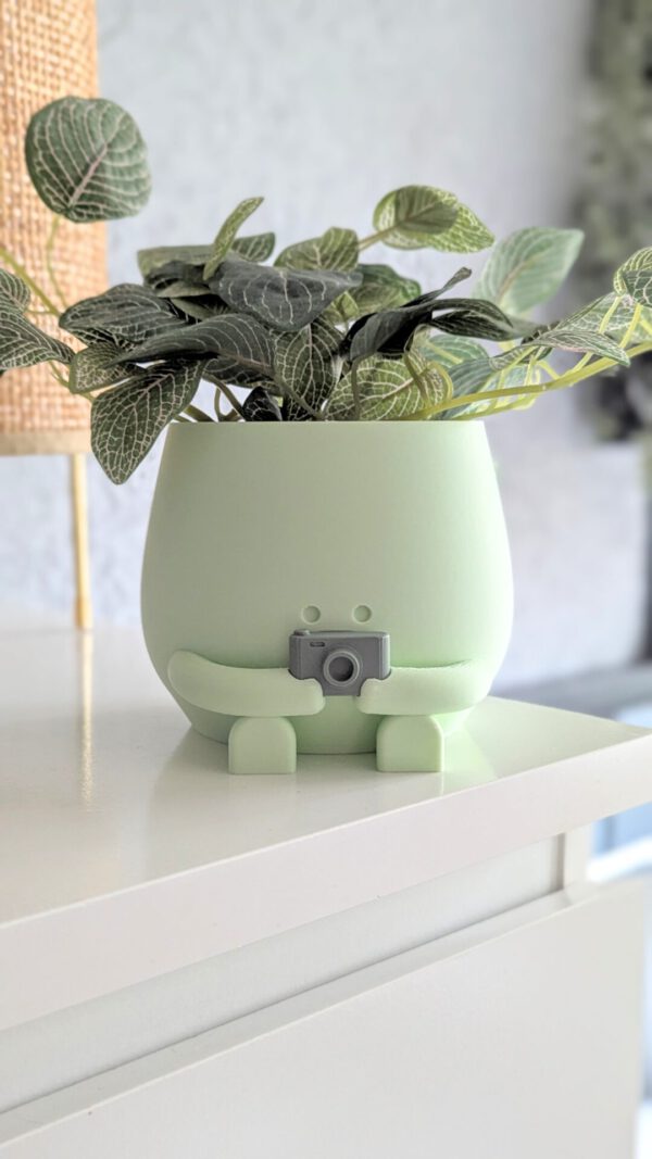 camera plant pot holding a camera